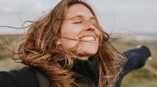 glückliche Frau steht im Wind