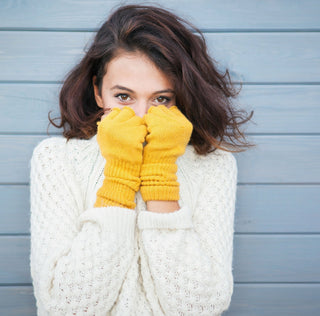 Frau schützt ihr Gesicht vor Kälte im Winter