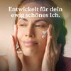 Eine Frau trägt die Nature Love Hyaluron Night Cream auf ihre Wangen auf, über ihr steht der deutsche Text "Entwickelt für dein ewig schönes Ich.